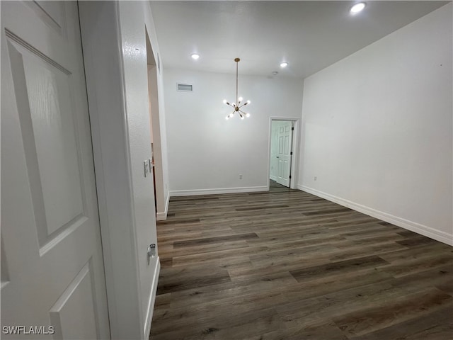 unfurnished room featuring a notable chandelier and hardwood / wood-style floors