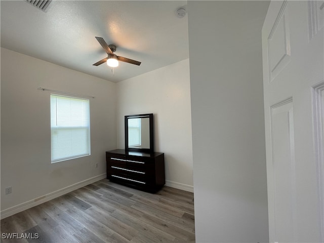 unfurnished bedroom with ceiling fan and hardwood / wood-style flooring