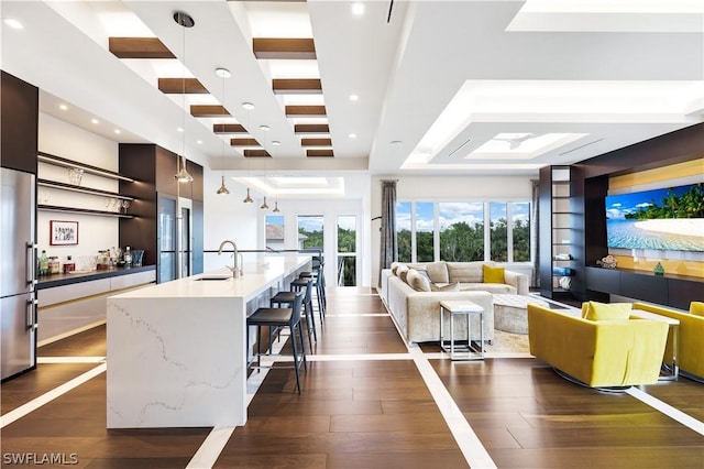 living room featuring sink and dark hardwood / wood-style flooring