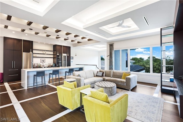 living room with dark hardwood / wood-style flooring and a raised ceiling