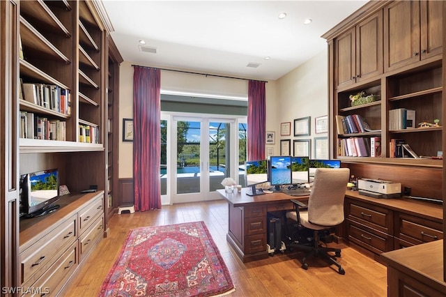 office area featuring built in shelves, light hardwood / wood-style floors, and french doors