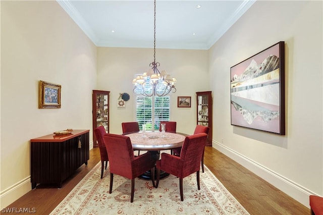 dining room with crown molding, an inviting chandelier, and light wood-type flooring