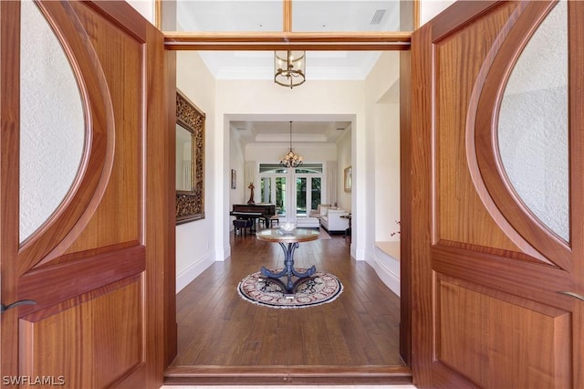 entryway featuring an inviting chandelier, crown molding, and wood-type flooring