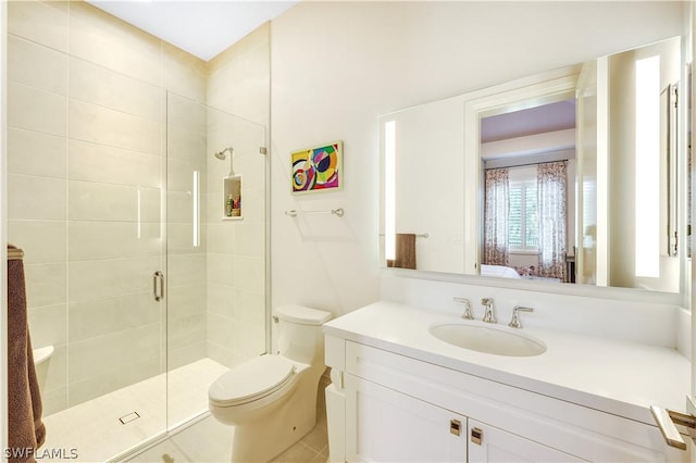 bathroom featuring toilet, vanity, and a shower with shower door