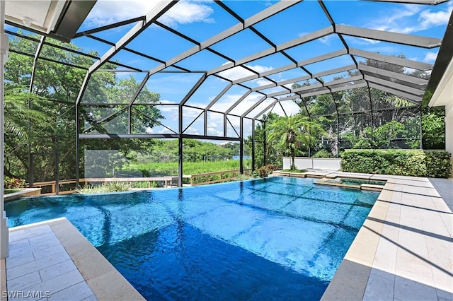 view of pool with a lanai, a patio area, and an in ground hot tub