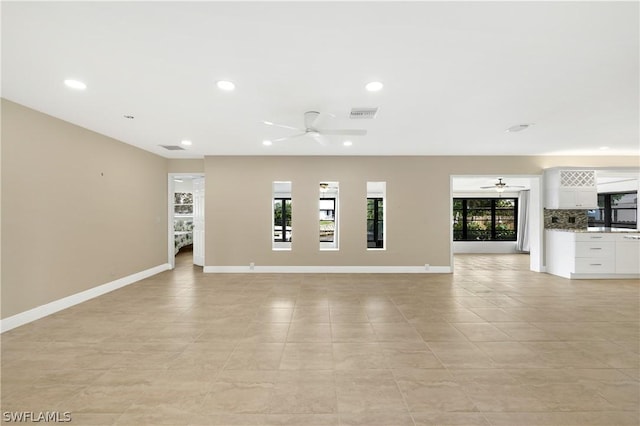 unfurnished living room with ceiling fan, recessed lighting, and baseboards