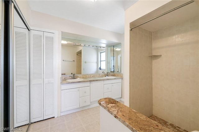 full bathroom with double vanity, a closet, and a sink