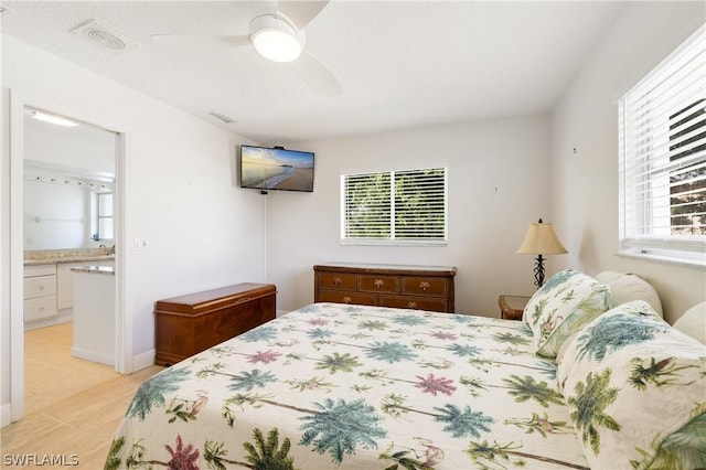 bedroom with ensuite bath, multiple windows, and visible vents