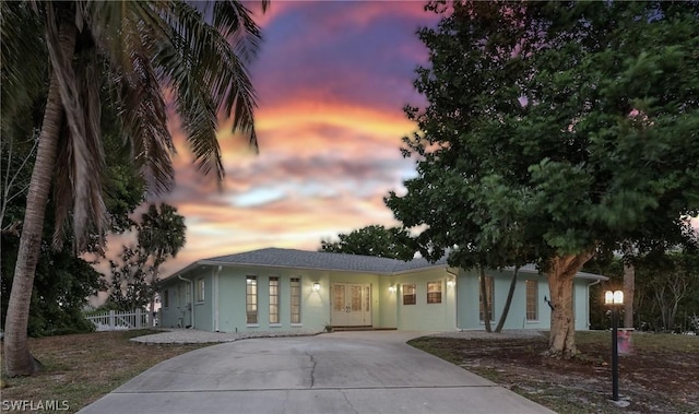 view of front of house featuring concrete driveway, fence, and stucco siding