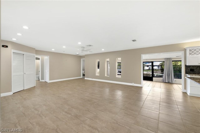 unfurnished living room with baseboards, visible vents, and recessed lighting