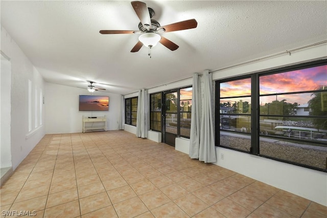 interior space featuring a textured ceiling, ceiling fan, and light tile patterned flooring