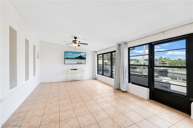 unfurnished room featuring a ceiling fan and light tile patterned flooring