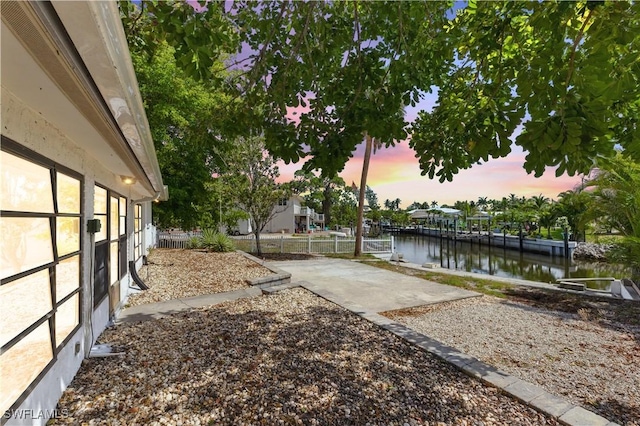 3461 Lakeview Dr, Naples, FL 34112 - yard at dusk featuring a water view and a patio