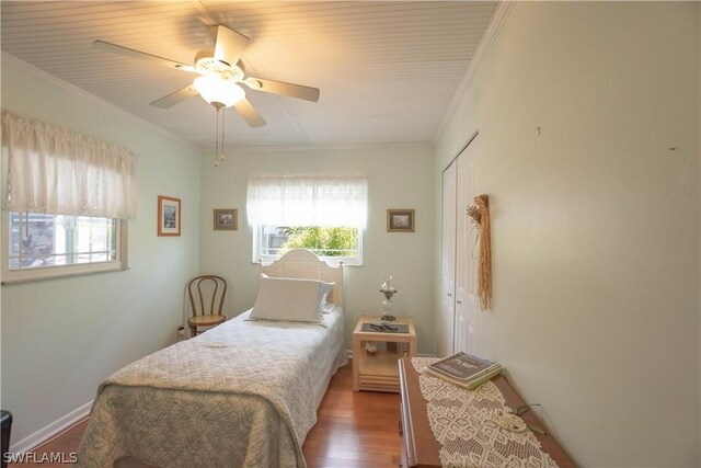 bedroom with ceiling fan, ornamental molding, wood-type flooring, and a closet