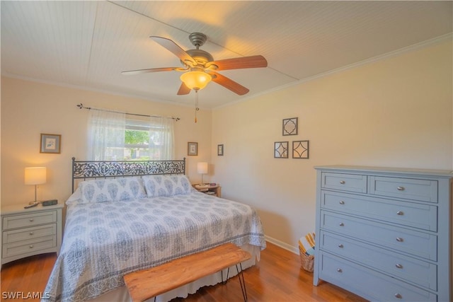 bedroom featuring ceiling fan, crown molding, and light wood-type flooring