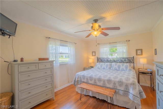 bedroom featuring light hardwood / wood-style floors, ceiling fan, and ornamental molding