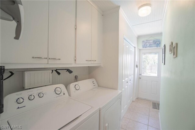 laundry room featuring cabinets, crown molding, washing machine and clothes dryer, and light tile patterned floors