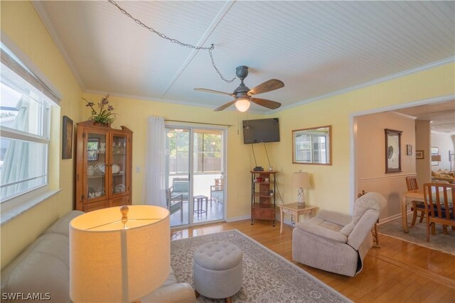 living room featuring light hardwood / wood-style floors, ornamental molding, and ceiling fan