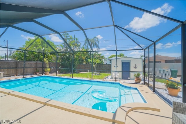 view of swimming pool featuring a storage unit, a patio, and a lanai