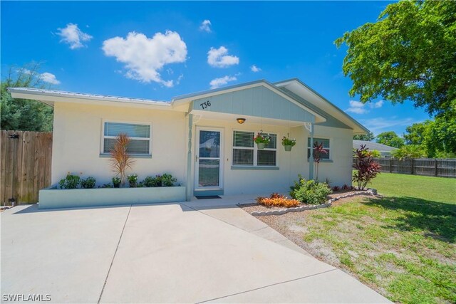 view of front of home with a front yard and a patio area