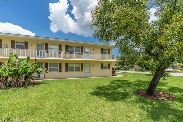 back of property featuring a yard and a balcony