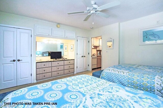 bedroom with light hardwood / wood-style floors, multiple closets, and ceiling fan