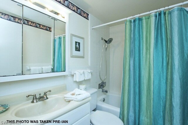 full bathroom featuring toilet, vanity, and shower / tub combo with curtain