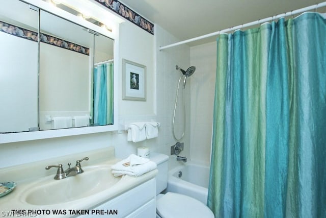 full bathroom with vanity, shower / bath combo with shower curtain, and toilet