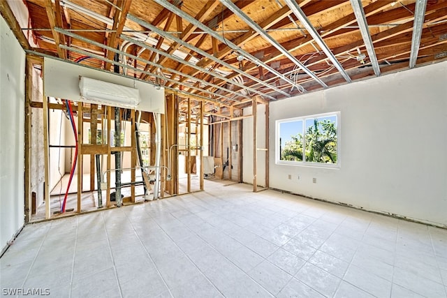 empty room featuring light tile patterned flooring and a wall unit AC