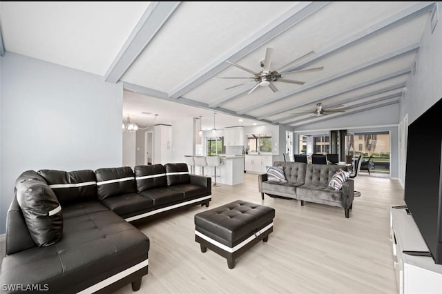 living room with ceiling fan with notable chandelier, light hardwood / wood-style floors, and lofted ceiling with beams