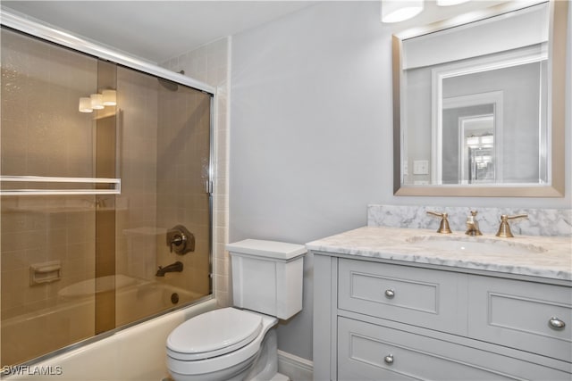 full bathroom featuring toilet, vanity, and enclosed tub / shower combo