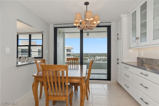 dining area with light tile patterned flooring, plenty of natural light, and a chandelier