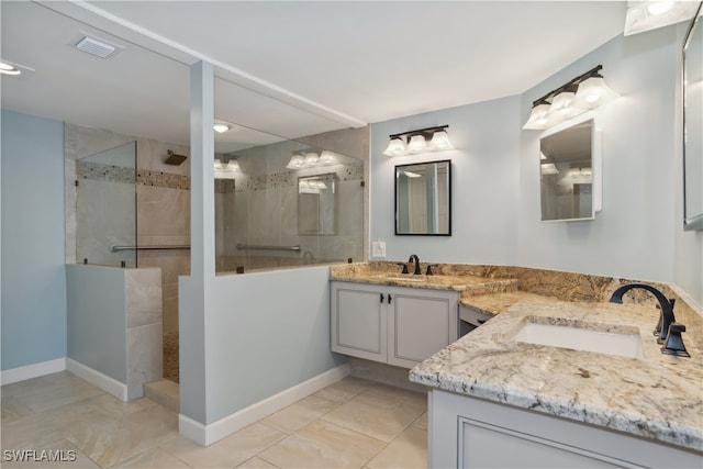 bathroom with tiled shower, tile patterned floors, and double sink vanity