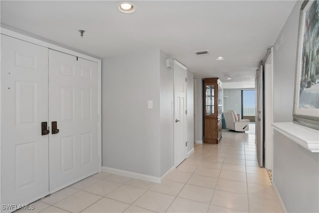 hall with light tile patterned floors