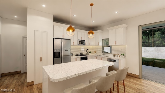 kitchen featuring backsplash, stainless steel appliances, white cabinetry, light wood-type flooring, and a kitchen island