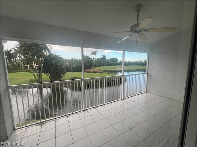 unfurnished sunroom featuring a water view and ceiling fan