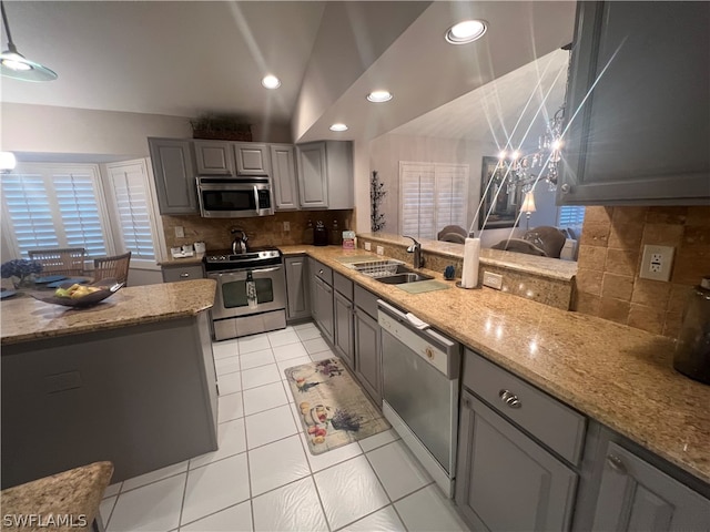 kitchen featuring tasteful backsplash, stainless steel appliances, gray cabinetry, sink, and light tile patterned flooring