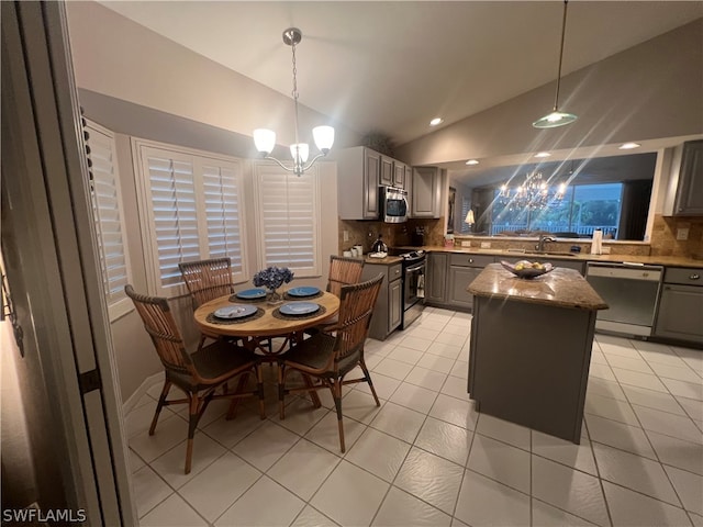 tiled dining space featuring an inviting chandelier, sink, and lofted ceiling