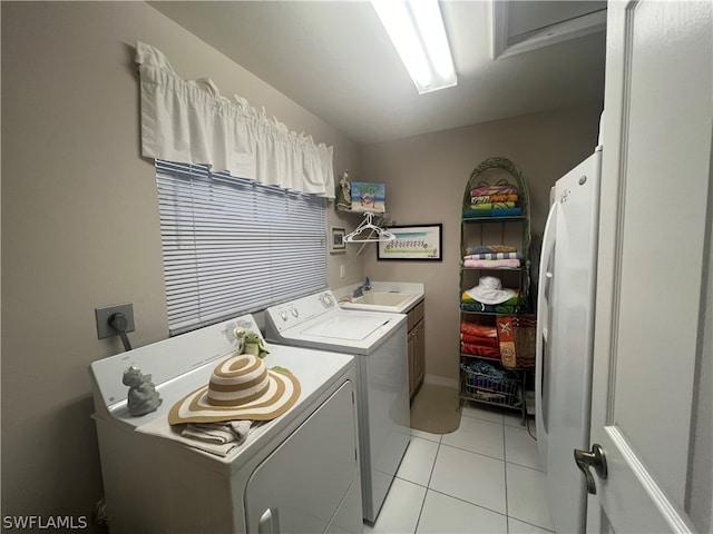 laundry room with cabinets, hookup for an electric dryer, sink, and light tile patterned floors