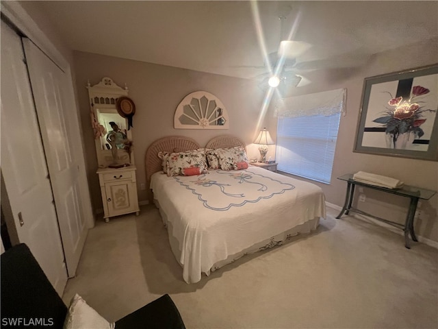 bedroom featuring ceiling fan, a closet, and light colored carpet