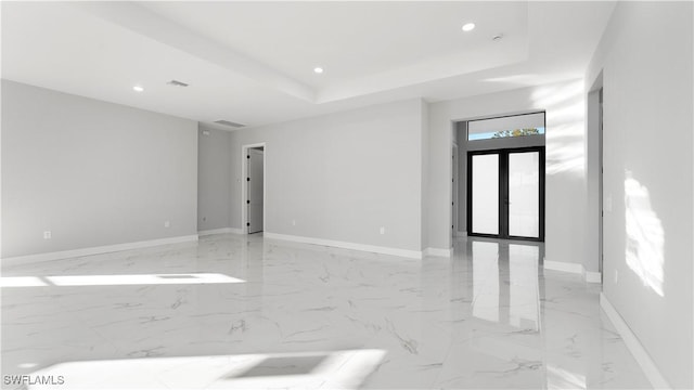 spare room featuring french doors and a tray ceiling