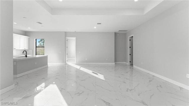 interior space featuring a tray ceiling and sink