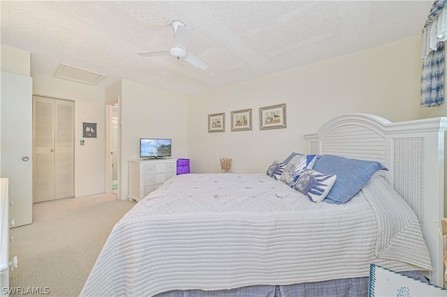 carpeted bedroom featuring ceiling fan and a textured ceiling