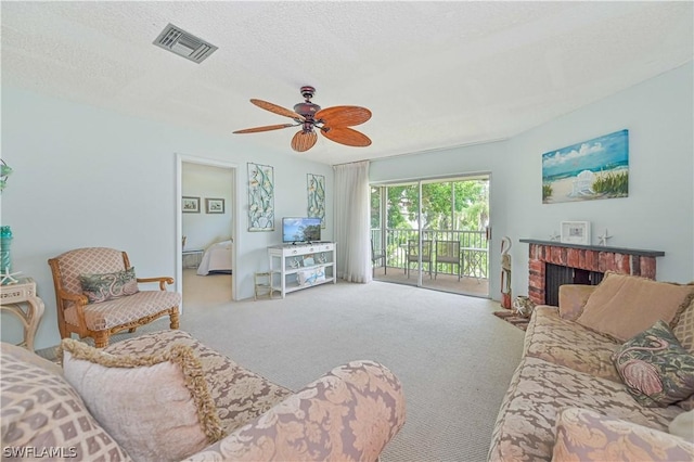 carpeted living room with a brick fireplace, a textured ceiling, and ceiling fan