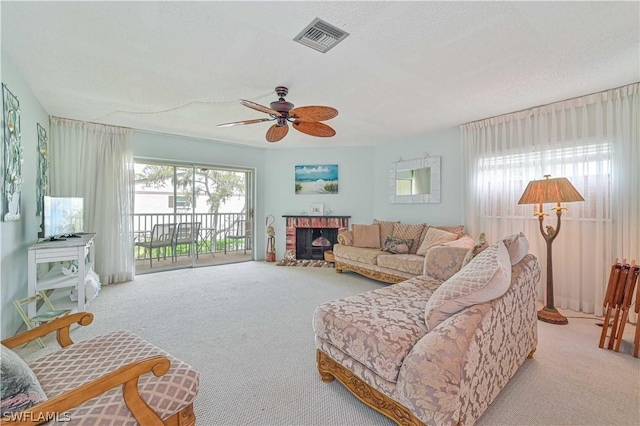 living room with ceiling fan, light carpet, a textured ceiling, and a fireplace