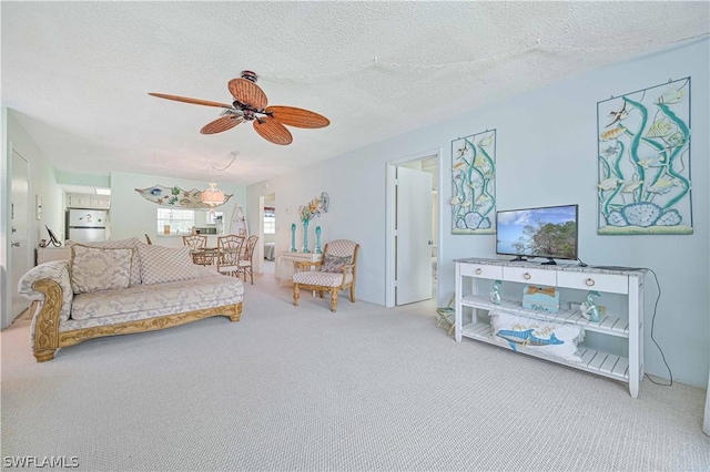 living room with ceiling fan, carpet, and a textured ceiling