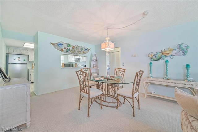 carpeted dining room with a textured ceiling