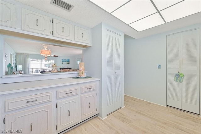 kitchen featuring white cabinetry and light hardwood / wood-style floors