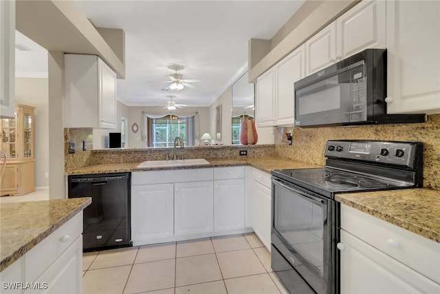 kitchen with white cabinetry, decorative backsplash, black appliances, and sink