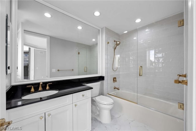 full bathroom featuring vanity, shower / bath combination with glass door, and toilet